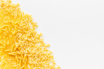 Uncooked pasta for italian food on white table background top view copyspace