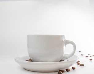Obraz na płótnie Canvas Coffee beans fall into a white porcelain cup and saucer, bouncing and jumping through the air conveying alert excitement, all isolated against a white background