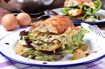 Panini sandwich with truffle mushroom, scrambled eggs and basil on white plate.
