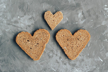 Rye bread in the shape of heart cut into slices on a gray background