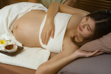 Obraz na płótnie Canvas Asian maternity sleep on bed,wait massage in spa ,treatment and relax.Healthy concept