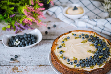Plate with decorated blueberry cheesecake on wooden white table