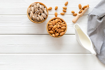 Almond milk with almonds on white wooden background top view copyspace