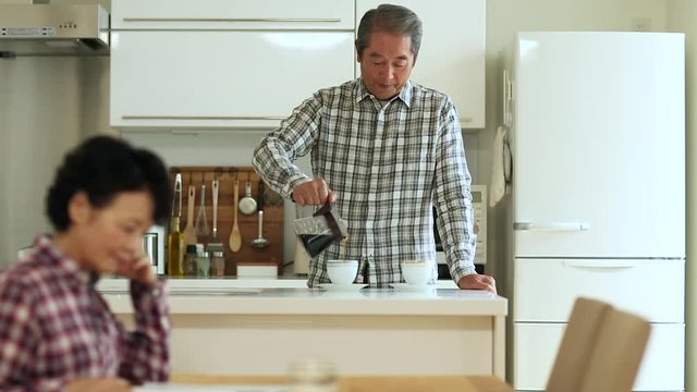 Senior man making coffee in kitchen at home