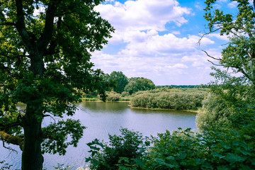 Fototapeta na wymiar European natural landscape of river and trees on bright sunny day
