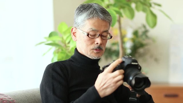 Senior man holding single lens reflex camera