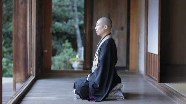 Priest sitting at temple, Kyoto, Japan