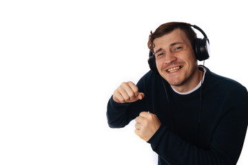 Fototapeta premium beautiful young man in headphones is dancing isolated on white background. The concept of International Music Day.