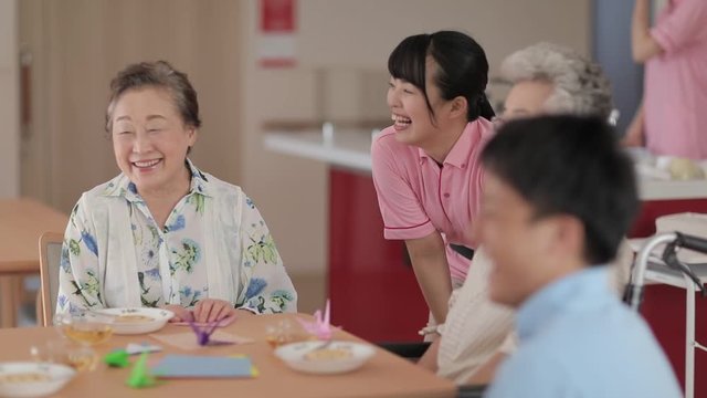 Caregivers talking to patients in nursing home canteen