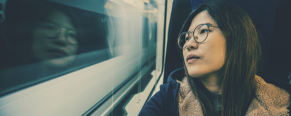 Fototapeta na wymiar Banner or web page of Asian Young lady passenger Sitting in depressed mood beside the window inside Train which travel between town when travel alone for escape the chaos,traveller and depress concept