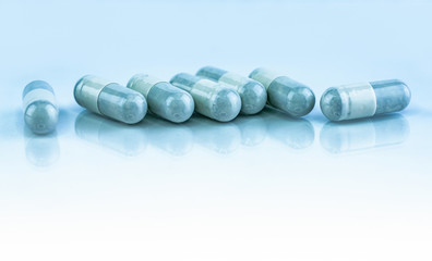 Herbal medicine in capsule pills on white background. Alternative medicine concept. Powder of herbal fill and pack in capsule. Pharmaceutical industry. Pharmacy drugstore background. Herbal drug pill.