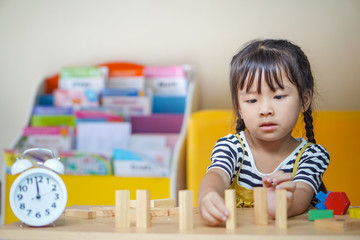happiness little girl learning construction with wooden blocks or wood blocks stack game. concept education.