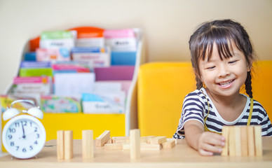happiness little girl learning construction with wooden blocks or wood blocks stack game. concept education.