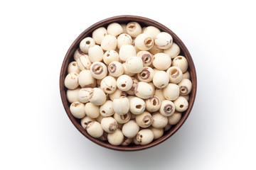 Dried lotus seeds in a wooden bowl isolated on white background. Top view.