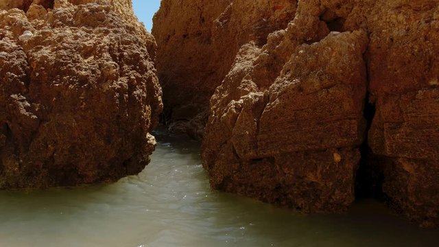 Slow motion shot of sea waves pounding against the rocks of Dona Ana Beach in Lagos, The Algarve, Portugal