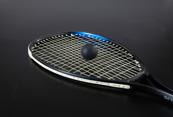 tennis racket with ball on black background