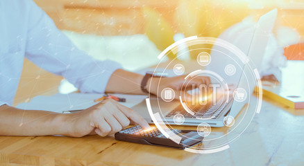 IOT : internet of thinks. Photo businessman working on modern loft office. Man sitting wood table and using contemporary notebook, texting message keyboard. Horizontal, film, flare effect