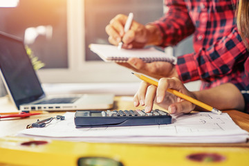 Architect concept, Architects working with blueprints in the office, hand working and laptop with on on architectural project at construction site at office desk in office
