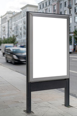 Moc up standard rectangular vertical lightbox on street in city. Advertising construction. Copy space. Lightbox on sidewalk wide street. Against backdrop building and roadway.