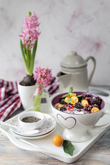 Homemade granola with nuts, chia seeds and fruit in a breakfast mug. Light photo.