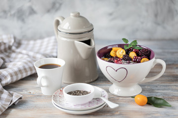 Homemade granola with nuts, chia seeds and fruit in a breakfast mug. Light photo.