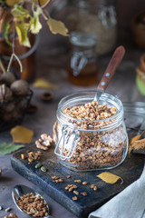 Homemade granola with nuts and seeds in glass jar for healthy breakfast