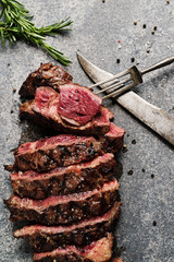 Prime Rib Steak on natural stone slab with old knife and fork