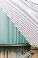 Water from rain flows over the edge of the roof of a village house in the gutter and flows on. Collection of drinking water of the Northern peoples of Yakutia.