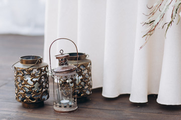 Copper candle holders with white candles as wedding decorations.