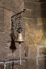 Fototapeta premium bell hanging on the stone wall of an old temple. Vertically.