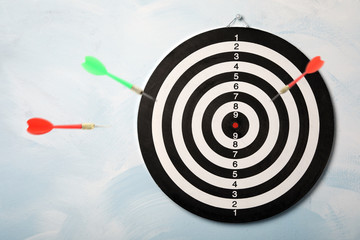 Color darts and board on light blue background