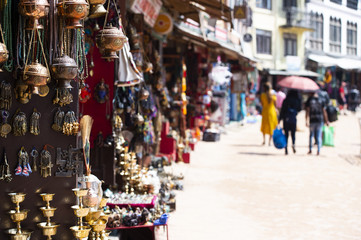 (Selective focus) Close-up view of some souvenirs (singing bowls, hand created statues and Rudraksha necklace) on a street market stall in Kathmandu Durbar Square, Kathmandu, Nepal.