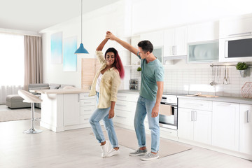 Beautiful couple dancing in kitchen at home