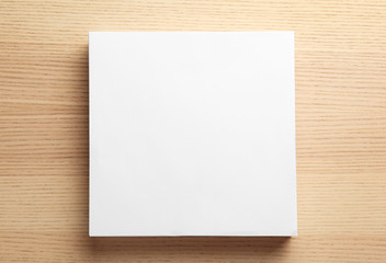 Stack of blank paper sheets for brochure on wooden background, top view. Mock up