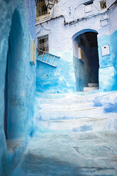 Stunning view of a narrow alleyway with the striking, blue-washed buildings. Chefchaouen, or Chaouen, is a city in the Rif Mountains of northwest Morocco.