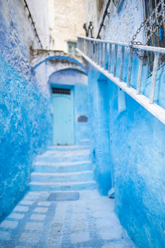 (Selective focus) Stunning view of a narrow alleyway with the striking, blue-washed buildings. Chefchaouen, or Chaouen, is a city in the Rif Mountains of northwest Morocco.