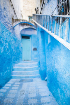 (Selective focus) Stunning view of a narrow alleyway with the striking, blue-washed buildings. Chefchaouen, or Chaouen, is a city in the Rif Mountains of northwest Morocco.