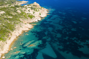 View from above, stunning aerial view of a green rocky coast bathed by a beautiful turquoise sea. Costa Smeralda (Emerald Coast) Sardinia, Italy.