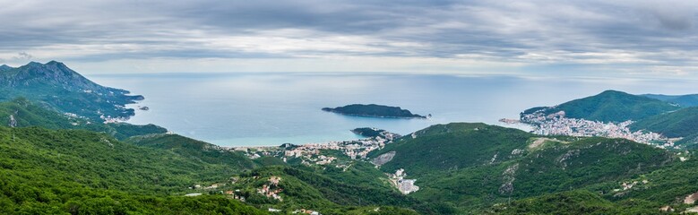 Montenegro, XXL panorama of city budva at the coast at the ocean from above green mountains covered by forest and trees nature landscape