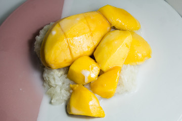 Mango sticky rice, Thai snacks, are arranged on a white plate.
