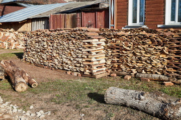 Pile of wooden firewood is stacked in the village