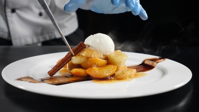 Mouthwatering ice-cream with flambe fried fruit in caramel sauce. Restaurant style food serving. Delicious dessert. Close up. Slow motion . 4k