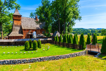 Old wooden church listed on Unesco list in Debno village on sunny summer day, Poland