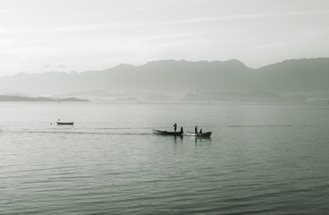 Two small boats in the sea with fog