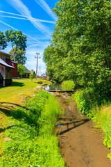 Fototapeta premium Small stream near Dunajec river on sunny summer day near Nowy Targ, Tatra Mountains, Poland