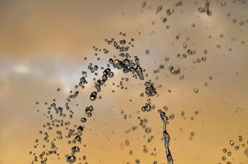 Water drops levitation flying on sunset background. Macro. Concepts: water, beackground, sunset abstract purity