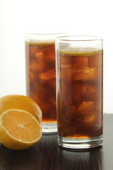 Glasses with cuba libre cocktail or cola with ice or cold tea with lemon