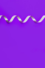 Holiday background with copy space. Silver spiral ribbon. Gift card or certificate. Proton Purple colored paper. Color trend 2019. Vertocal format.