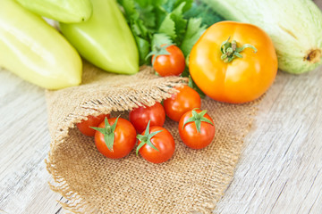 close up of freshly pickled harvest of vegetbles - bell pepper, drill and tomatoes on wooden table. Rustic style. Organic healthy food concept with copy space