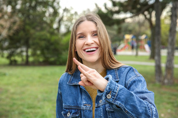 Young deaf mute woman using sign language outdoors © Pixel-Shot